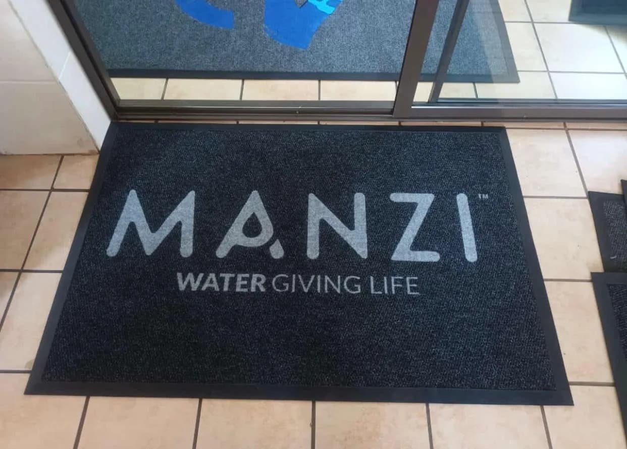 Charcoal entrance mat with a light corporate wordmark