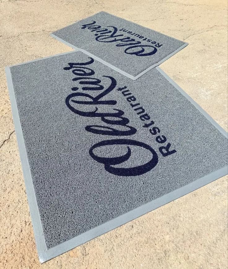 Light grey branded mat with a restaurant script logo