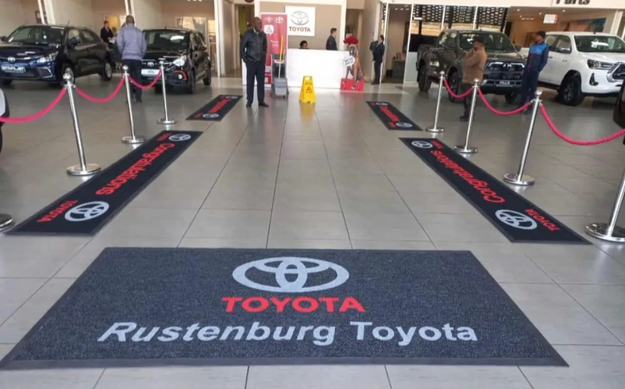 Pair of branded runner mats laid through a vehicle showroom