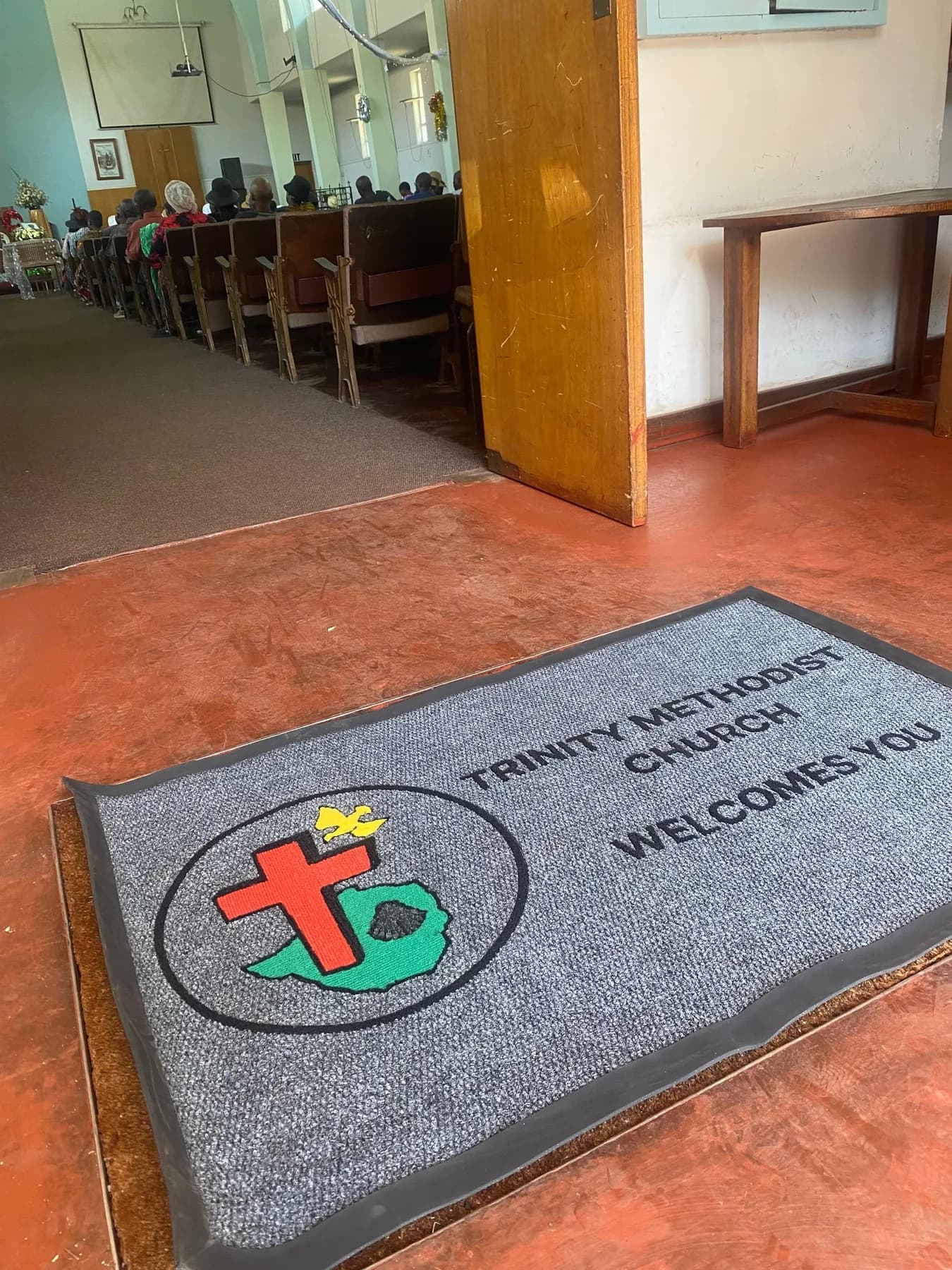 Church entrance mat with a tufted crest and welcome message