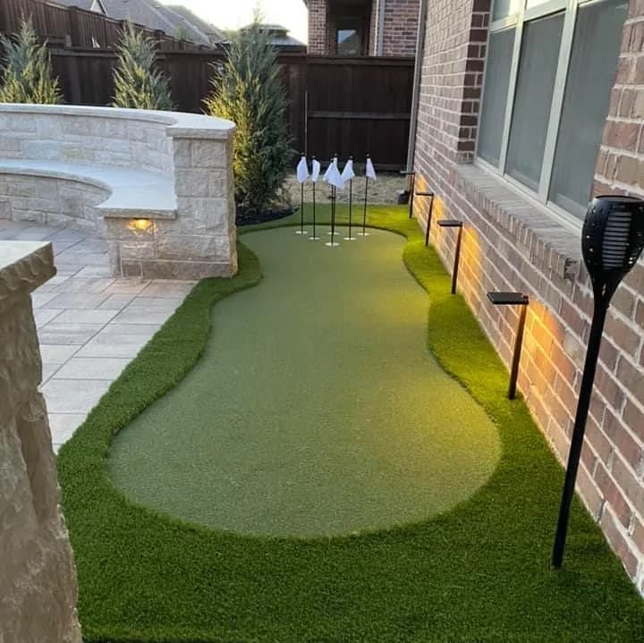 Curved patio putting green lit at night