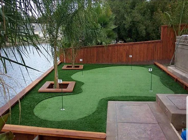 Putting green laid beside a swimming pool and deck