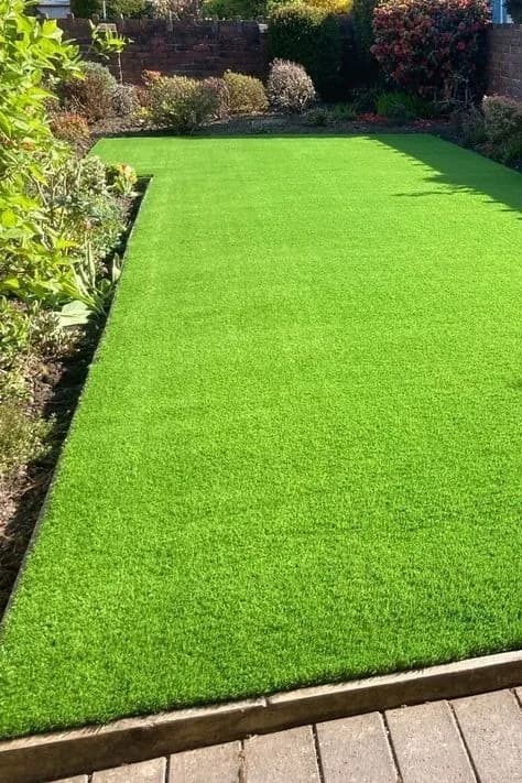 Artificial lawn meeting a timber deck edge