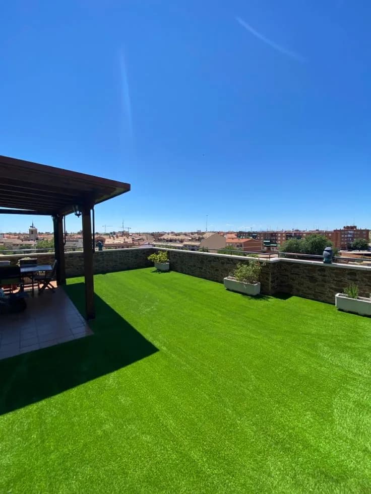 Rooftop terrace laid with artificial grass under a blue sky