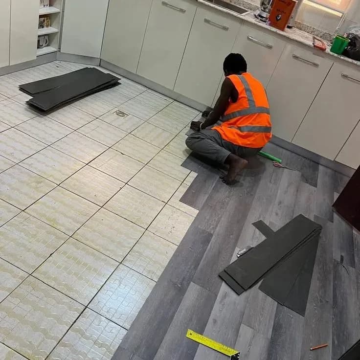 Tiler setting out large-format tiles in a kitchen