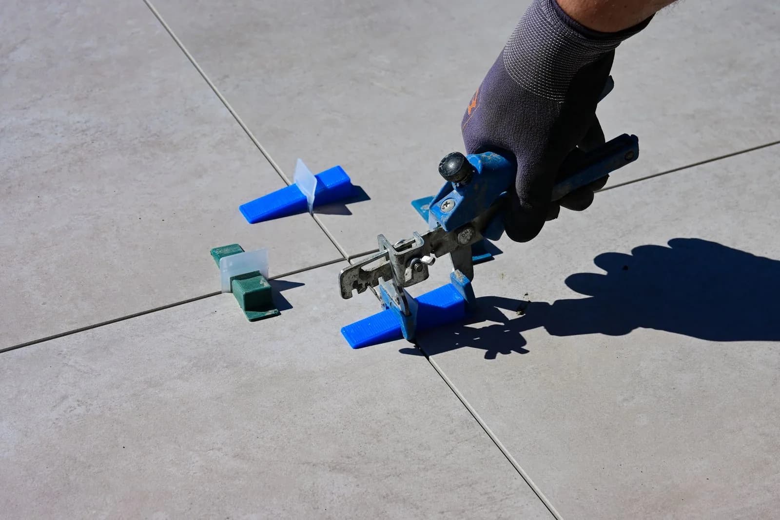 Levelling clips set between freshly laid floor tiles