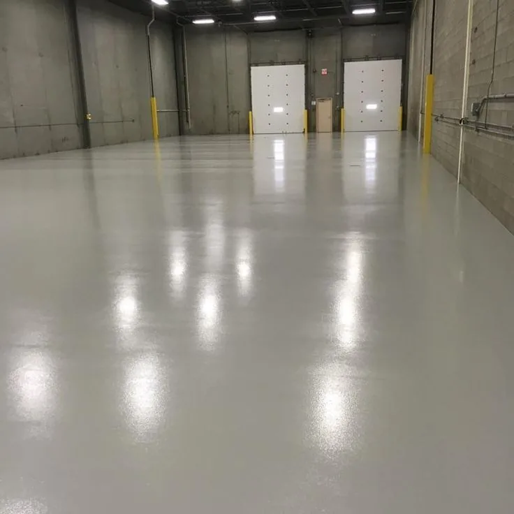 Glossy grey epoxy floor running the length of an industrial hall